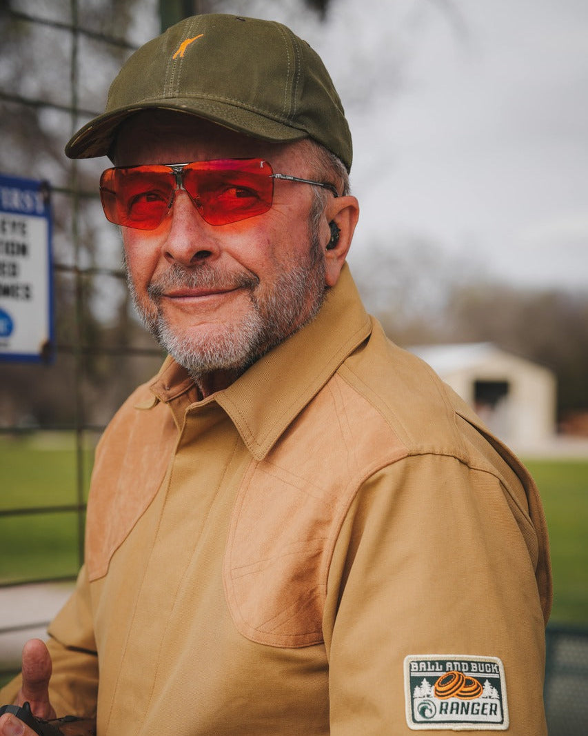 Shooter in an olive cap wearing the Ranger x Ball and Buck Edge glasses with orange-red lenses