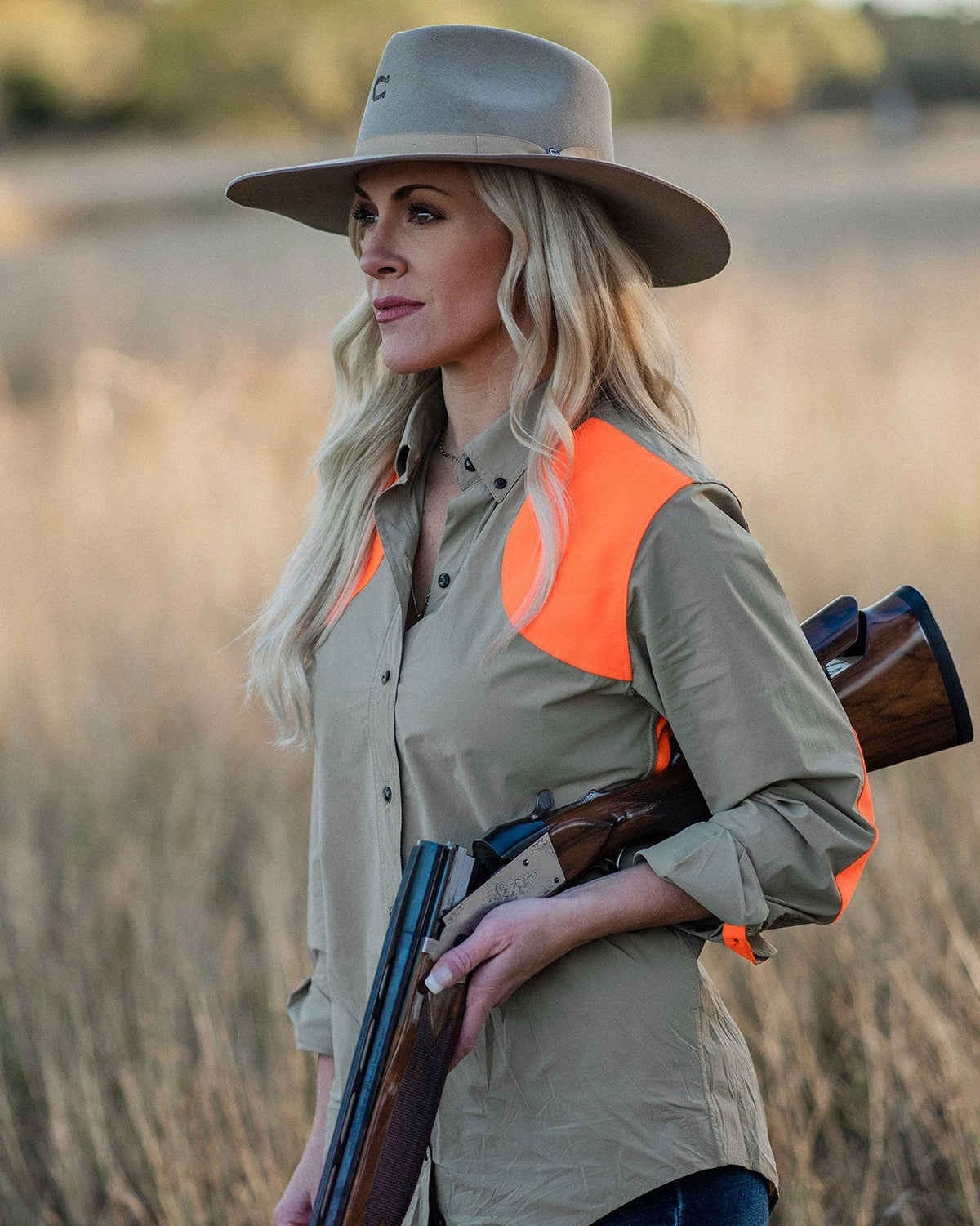 Woman in a wide-brim hat carrying a shotgun in the Active+ Joan Field Shirt in Upland