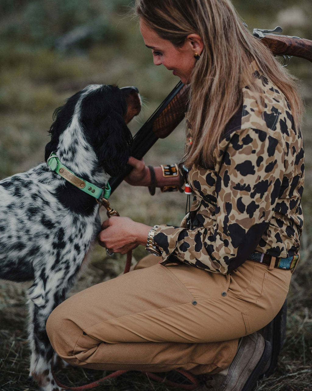 Woman kneeling with a setter wearing the Active+ Joan Field Pant in Signature