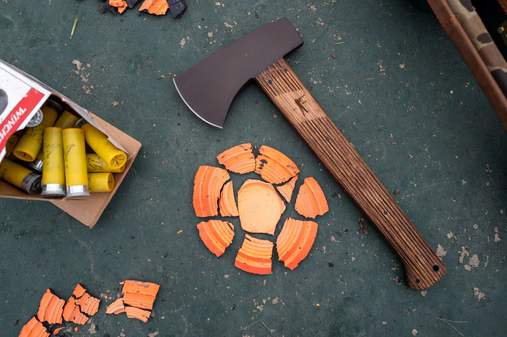 Winkler Highland Hatchet on a table with shotgun shells and broken clay targets