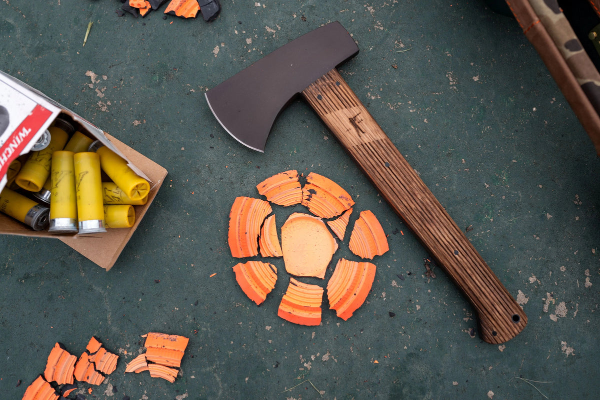 Winkler Highland Hatchet on a table with shotgun shells and broken clay targets