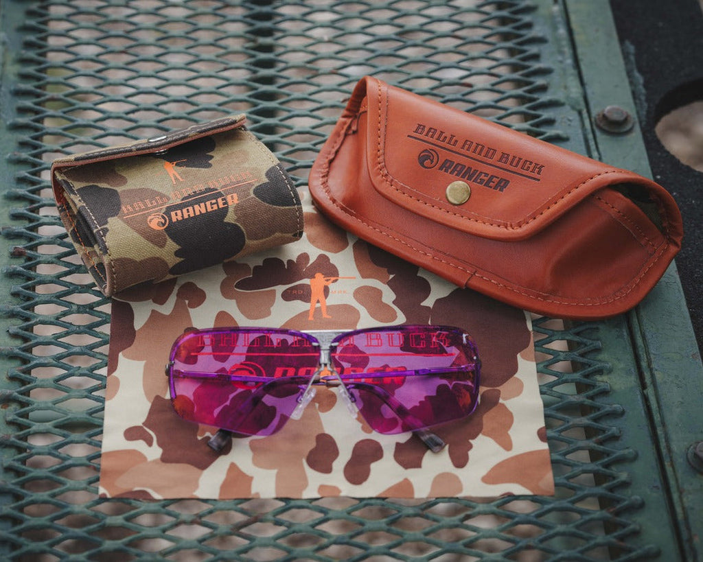 Max Light and Dark Purple Ranger lenses with the camo lens pouch and cognac case on a table