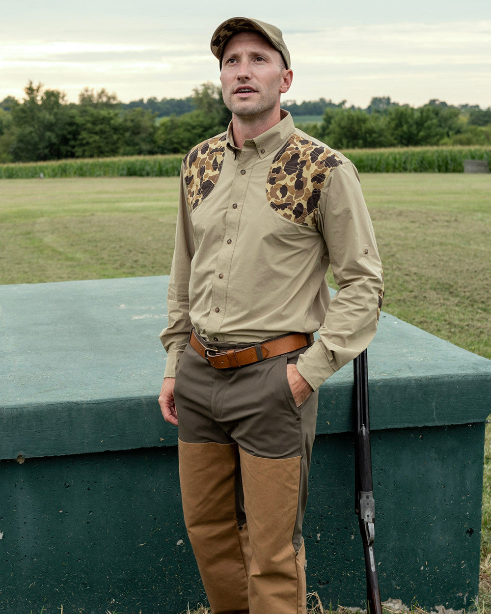 Man in a camo-shoulder field shirt and Loden Active+ Field Pant standing by a truck