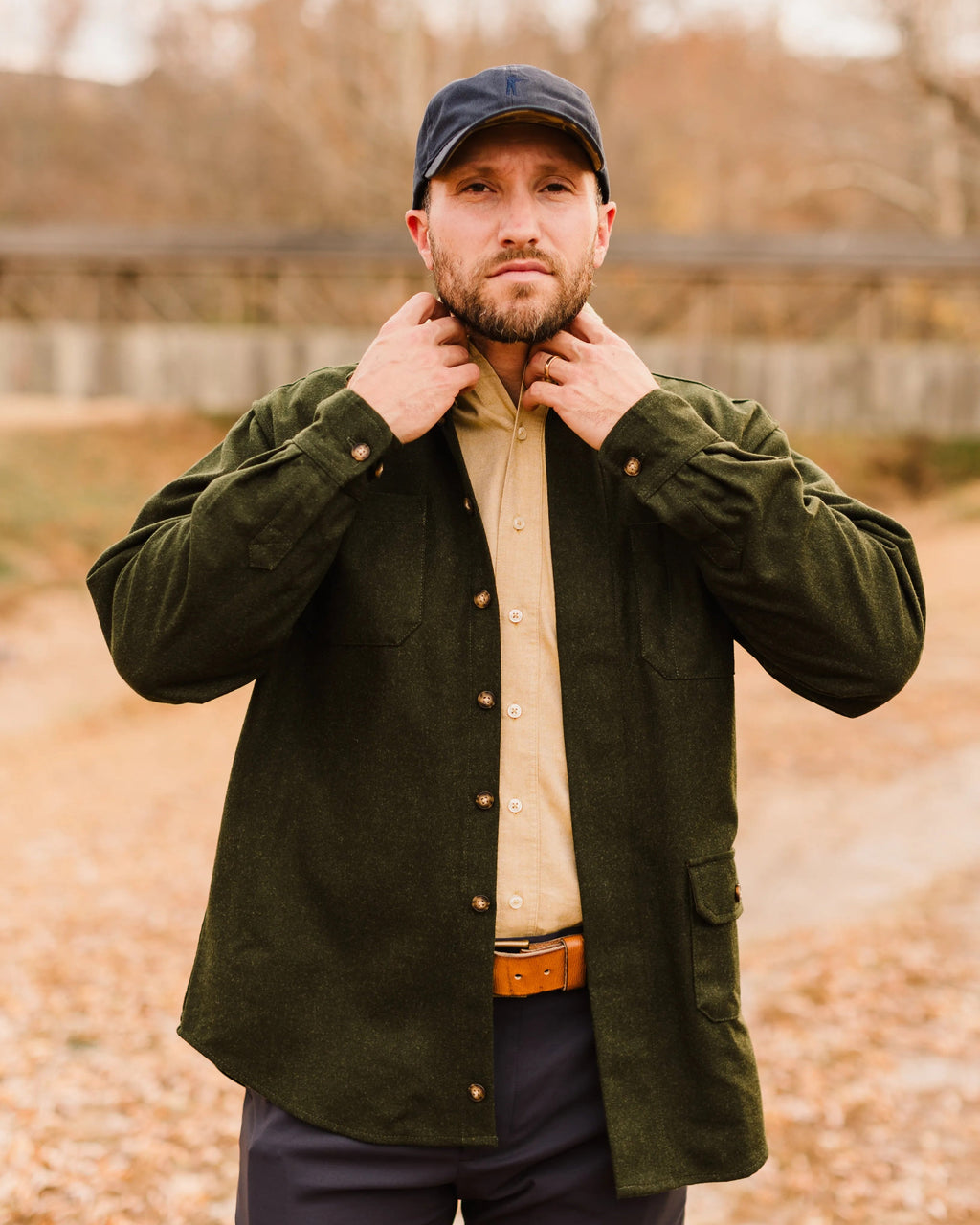 Man adjusting the collar of the Loden Green Mariners merino wool overshirt