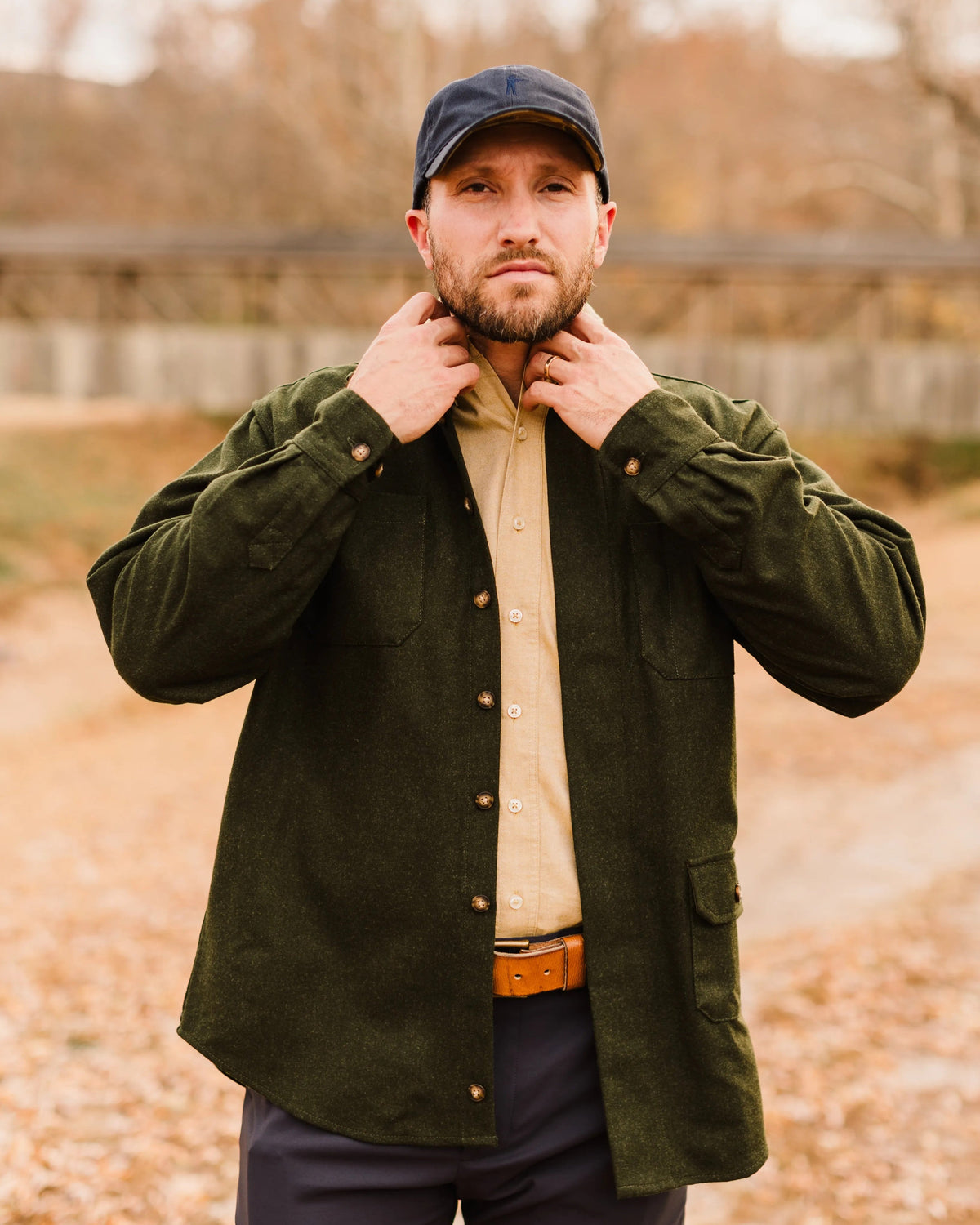 Man adjusting the collar of the Loden Green Mariners merino wool overshirt