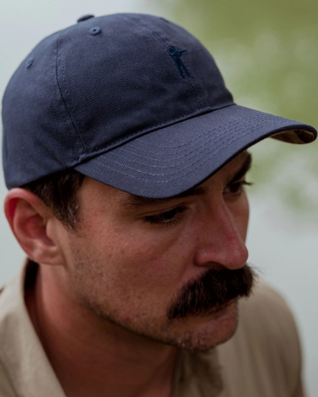 Man wearing the Navy Blue Arthur Core Hat, side profile