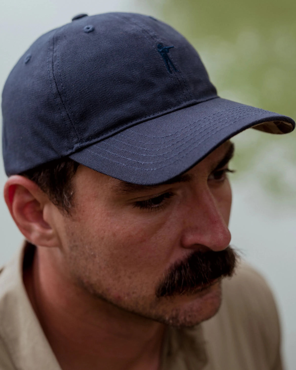 Man wearing the Navy Blue Arthur Core Hat, side profile
