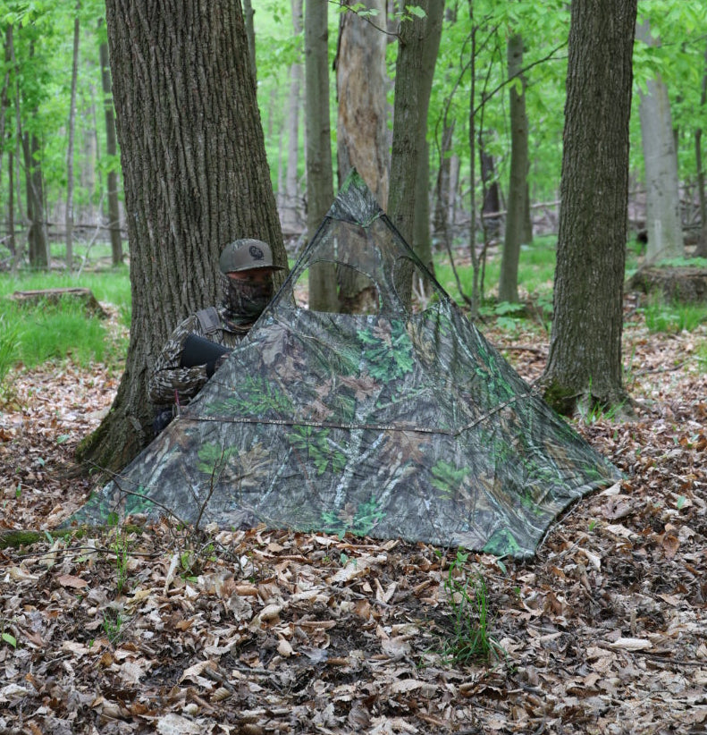 Camo hunting blind in forest, blending with trees for deer hunting concealment
