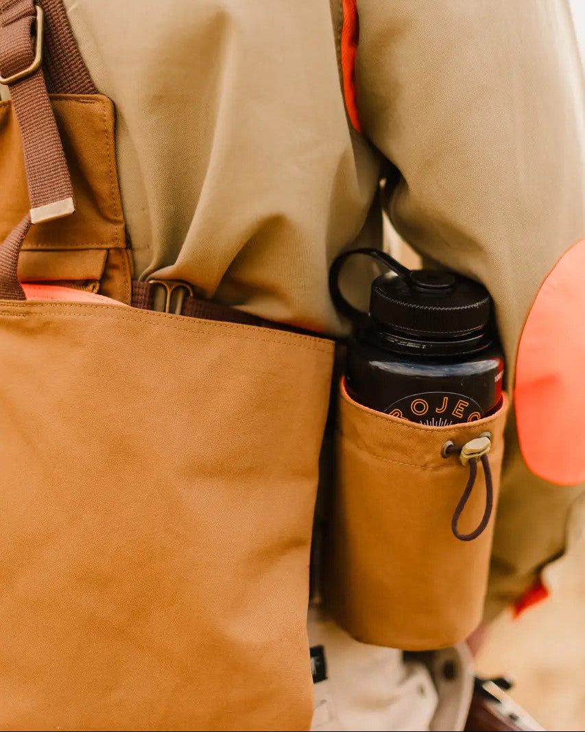 Side view of the Signature Canvas Strap Vest worn with a water bottle in the holder
