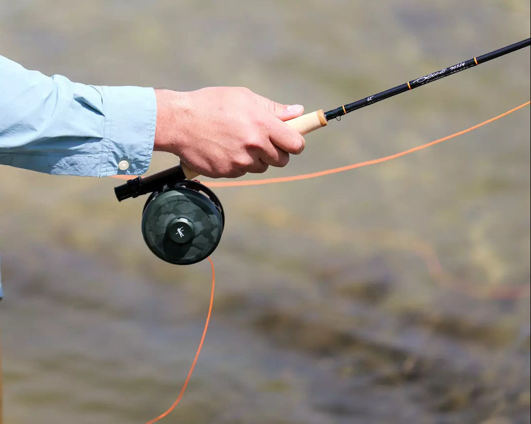 Hand gripping the Scott x Ball and Buck Centric fly rod while fighting a fish