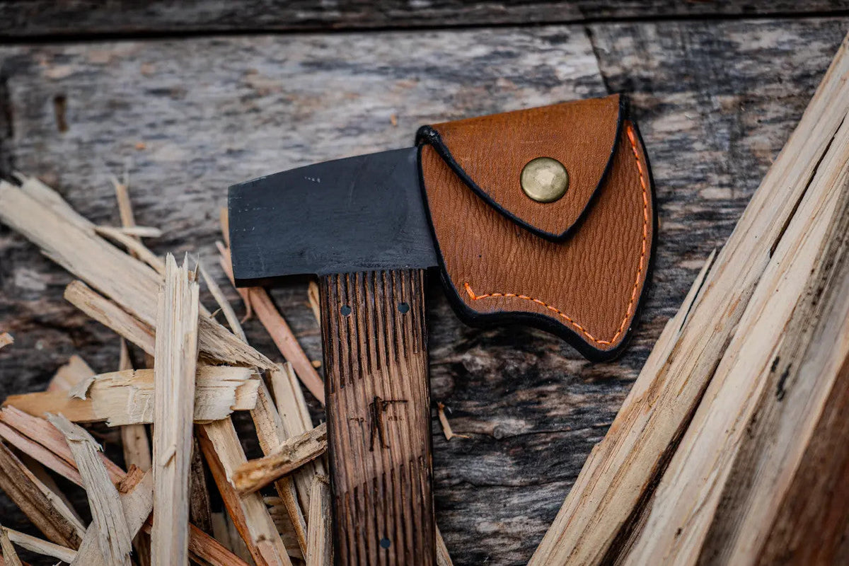 Black oxide head of the Winkler Highland Hatchet beside its Ball and Buck leather cover
