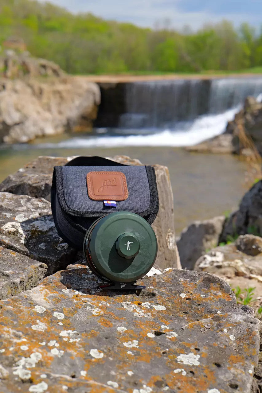 Abel x Ball and Buck ROVE fly reel and reel case on a rock beside a waterfall