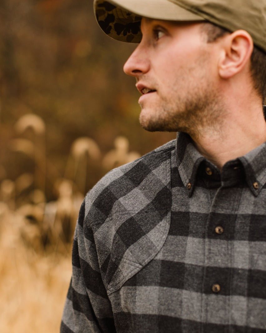 Close-up of a man in a field cap wearing the Grey Buffalo Plaid Sportsmans Shirt