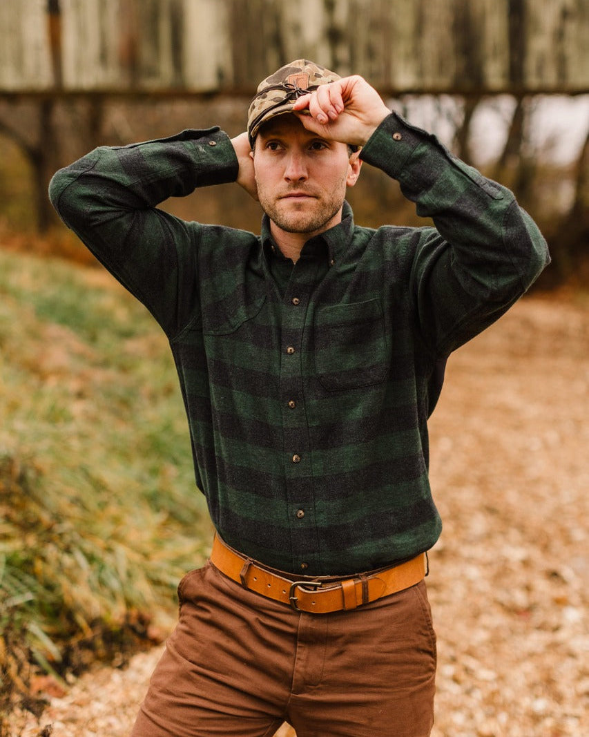 Man adjusting his cap while wearing the Green Buffalo Plaid Sportsmans Shirt