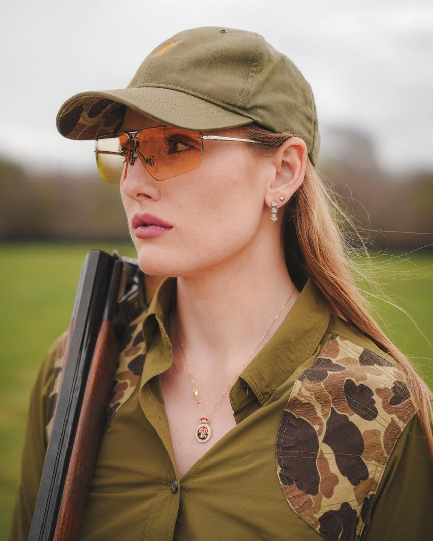 Woman wearing Ranger shooting glasses with a light lens, holding a shotgun