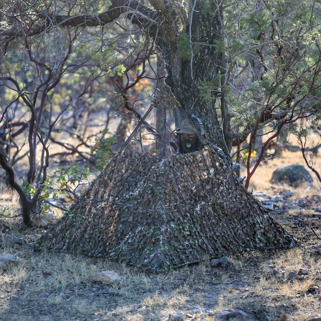 Camouflage hunting blind with leafy pattern, blending into woodland for stealthy outdoor hunting