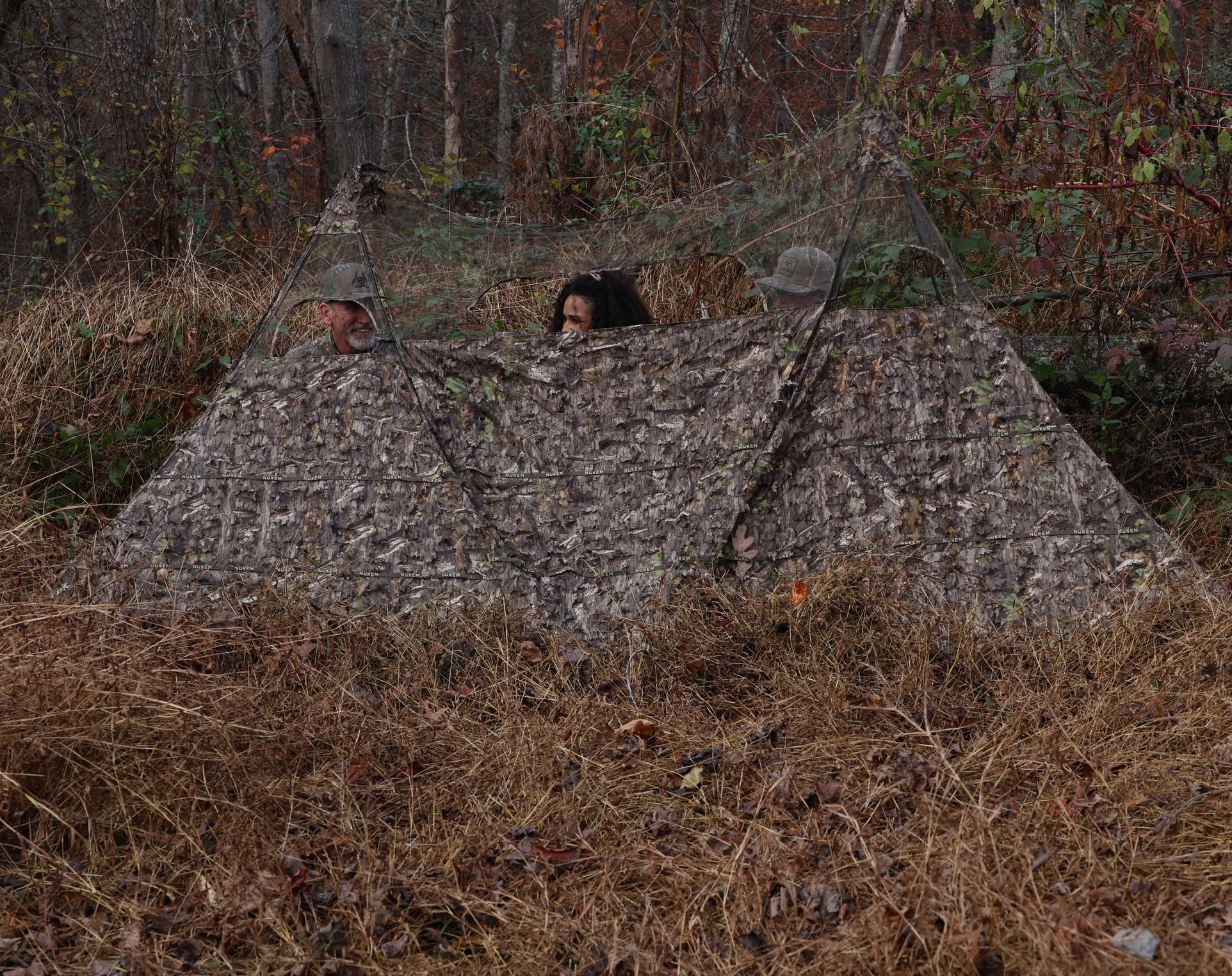 Camouflage hunting blind with leaf pattern, blending into forest for deer hunting and wildlife observation