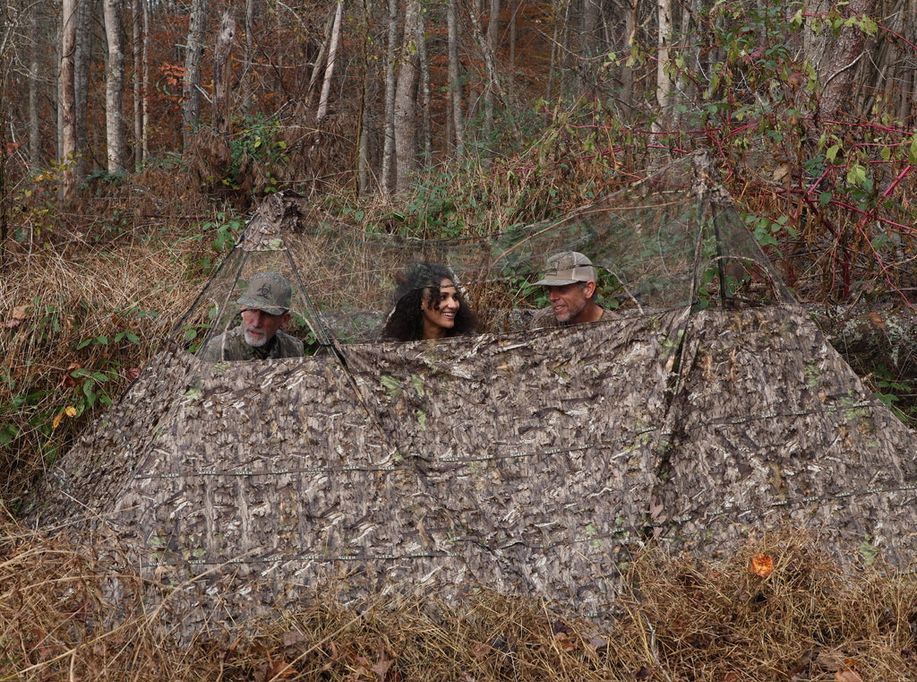 Camo hunting blind with mesh windows for concealment in woodland, ideal for deer hunting and wildlife observation