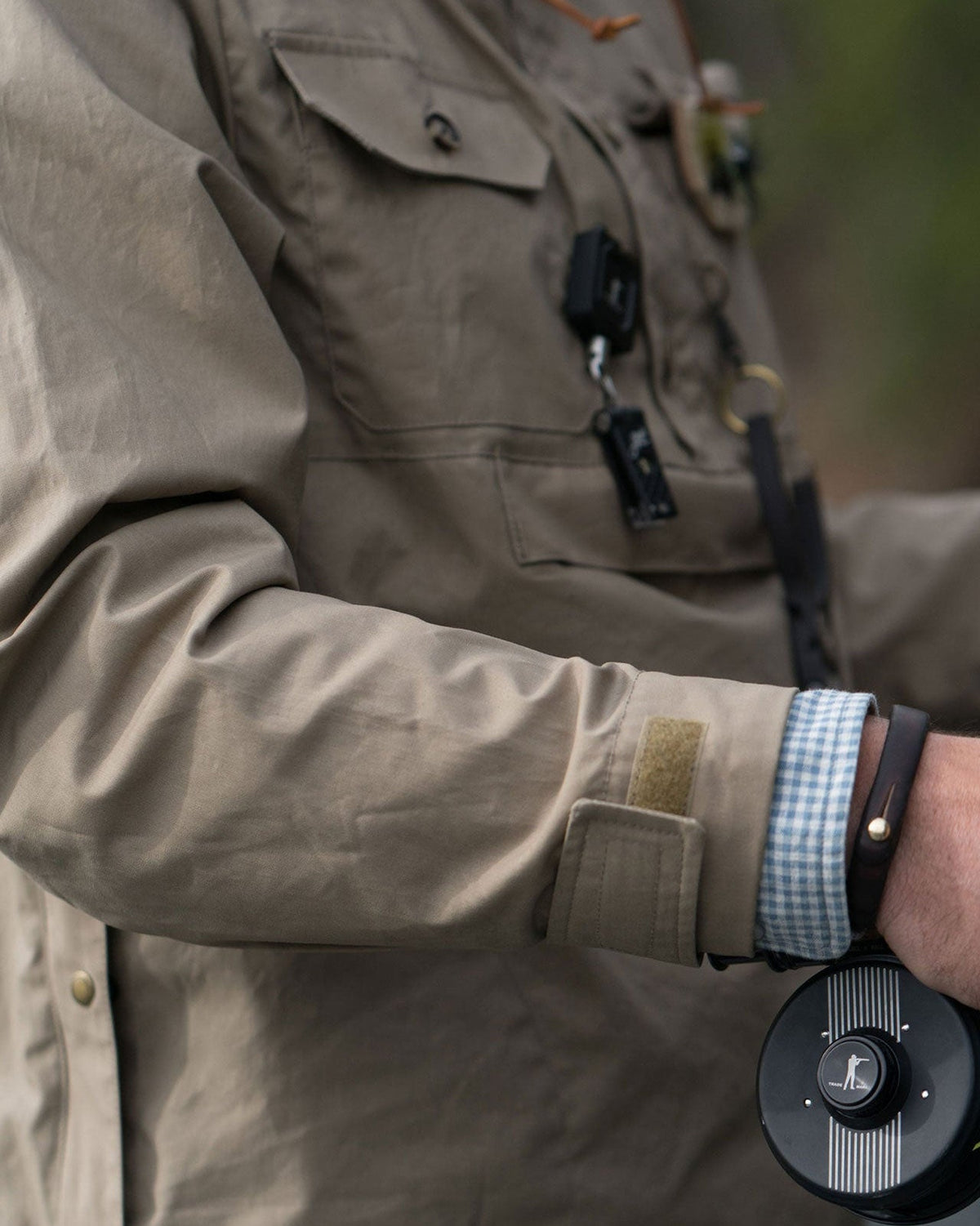 Angler wearing the Waxed Cotton Anorak with a fly reel clipped to the D-ring