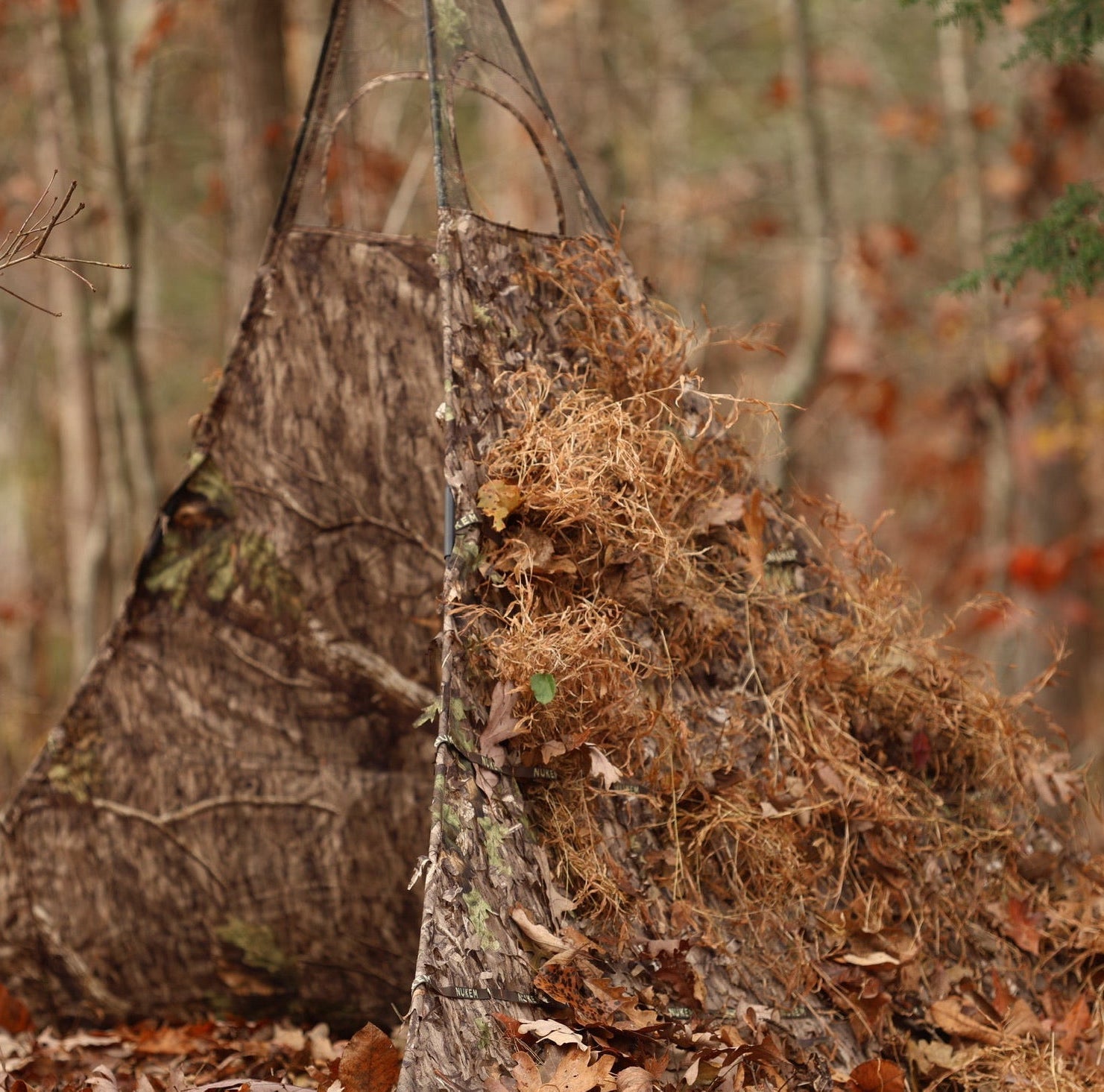 Camo hunting blind with leafy camouflage for woodland concealment