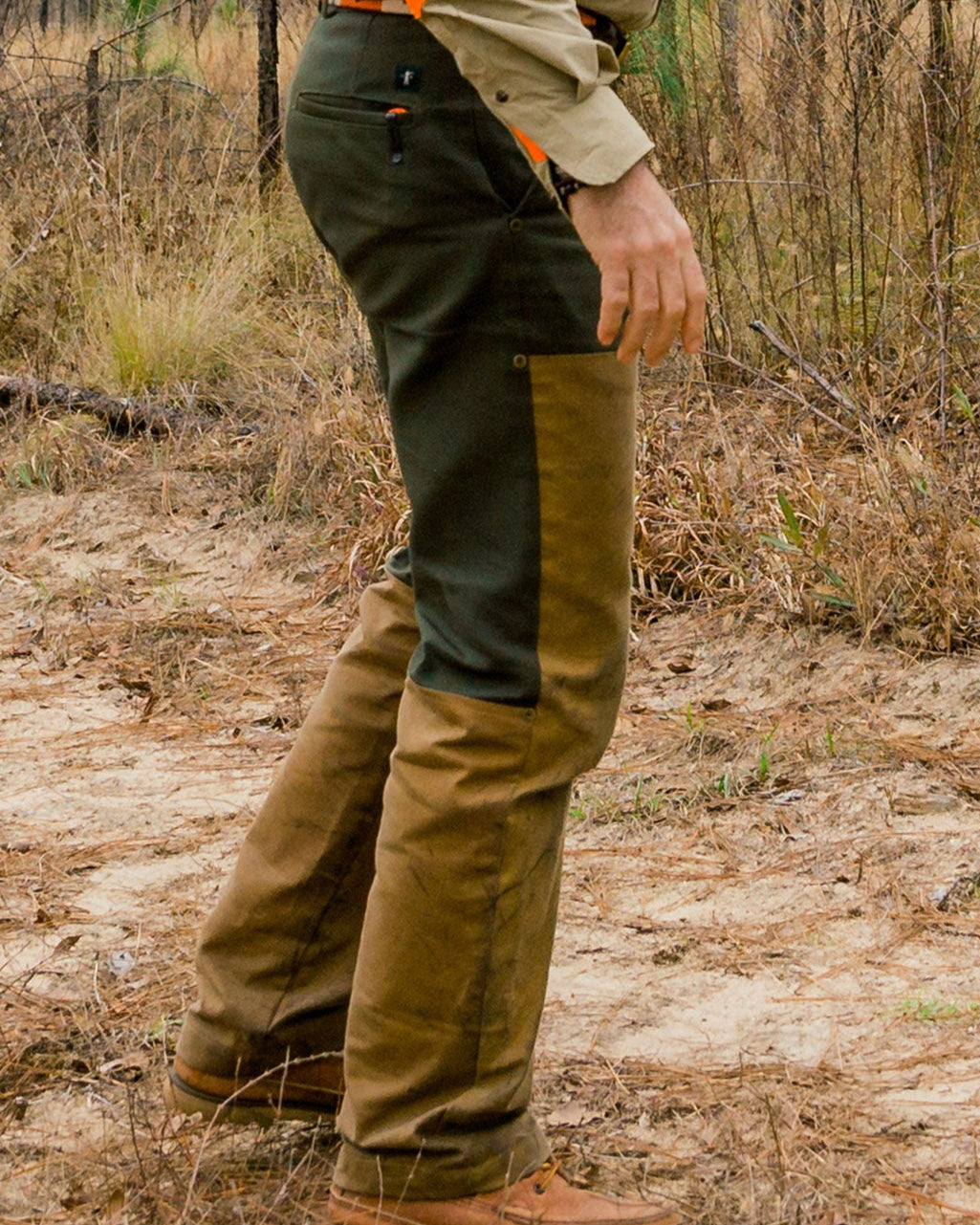 Hunter wearing the Pine Duck Midweight Field Pant walking through dry brush