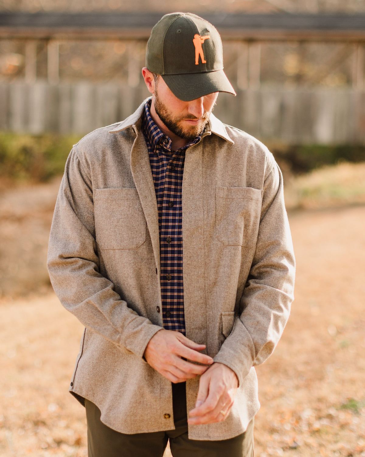 Man in a tan overshirt wearing the Olive Arthur Core Snapback outdoors