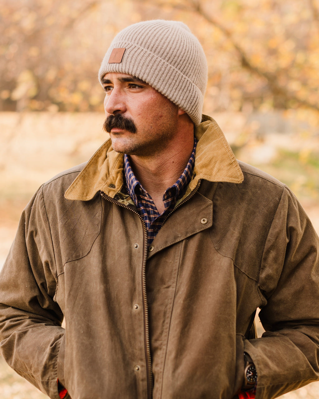 Man in a tan beanie wearing the Dark Oak Upland Jacket, hands in the moleskin pockets