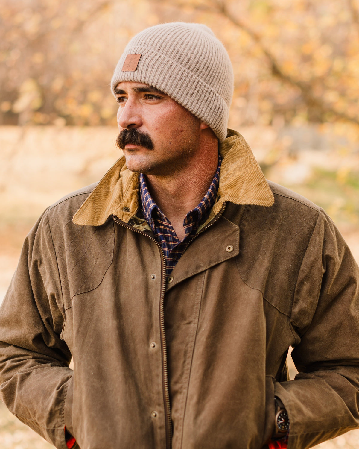 Man in a tan beanie wearing the Dark Oak Upland Jacket, hands in the moleskin pockets