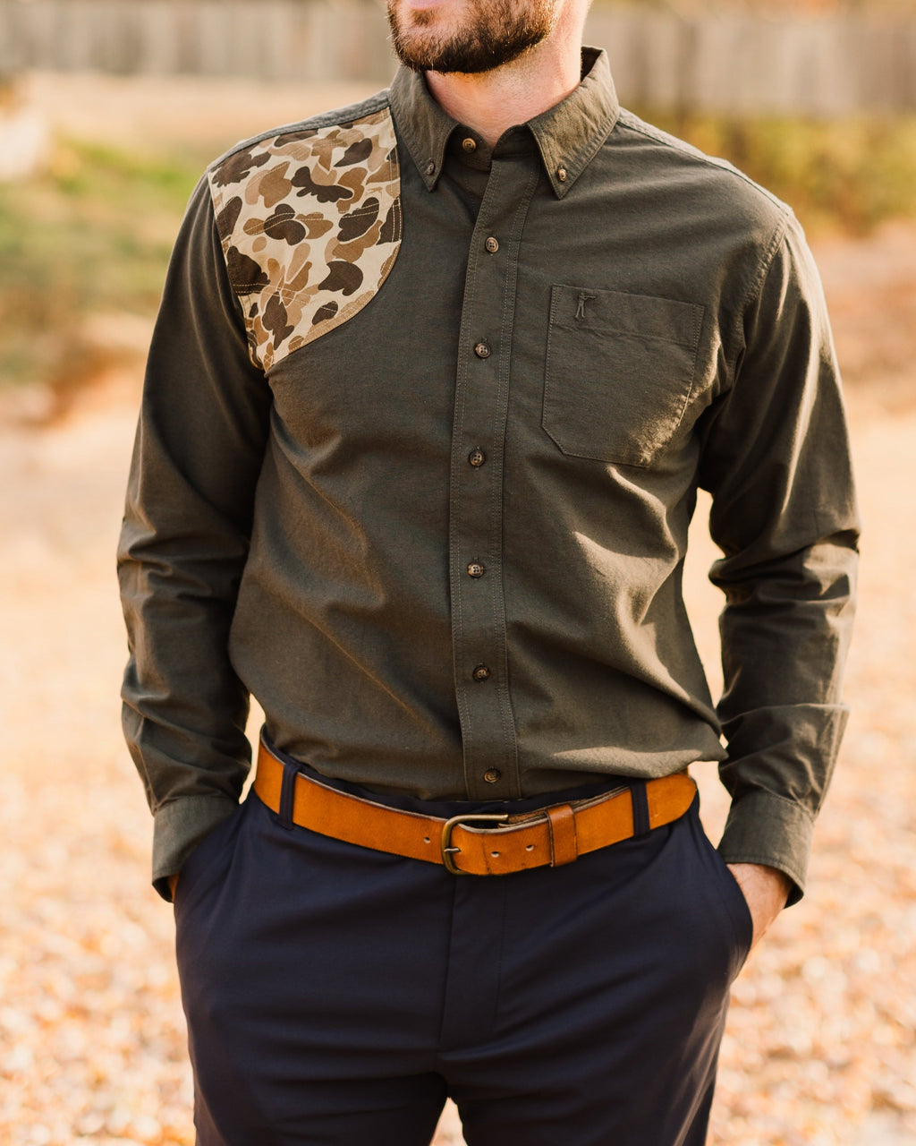 Man wearing the Moss Oxford Sportsmans Shirt tucked into navy pants with a leather belt