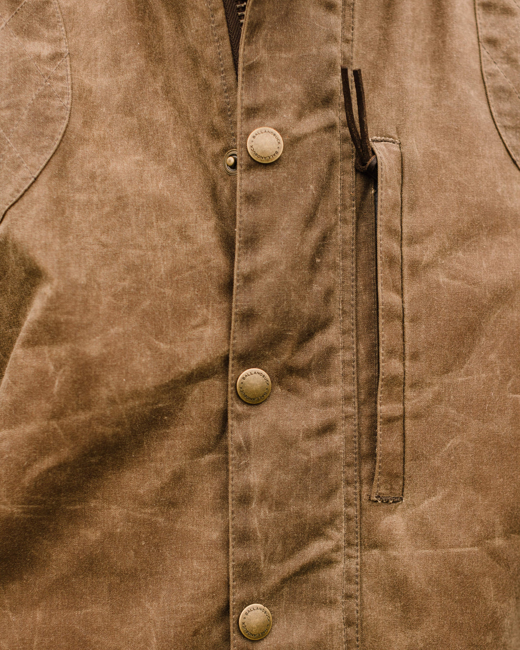 Close-up of the Dark Oak waxed cotton shell and front zipper on the Upland Vest