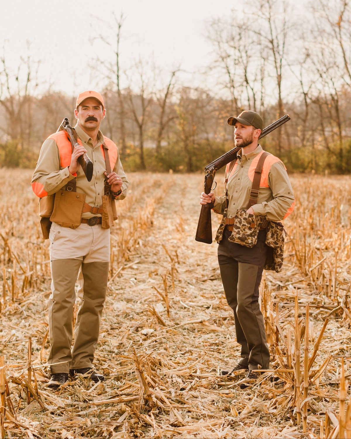 Two upland hunters in a cut corn field wearing Ball and Buck strap vests