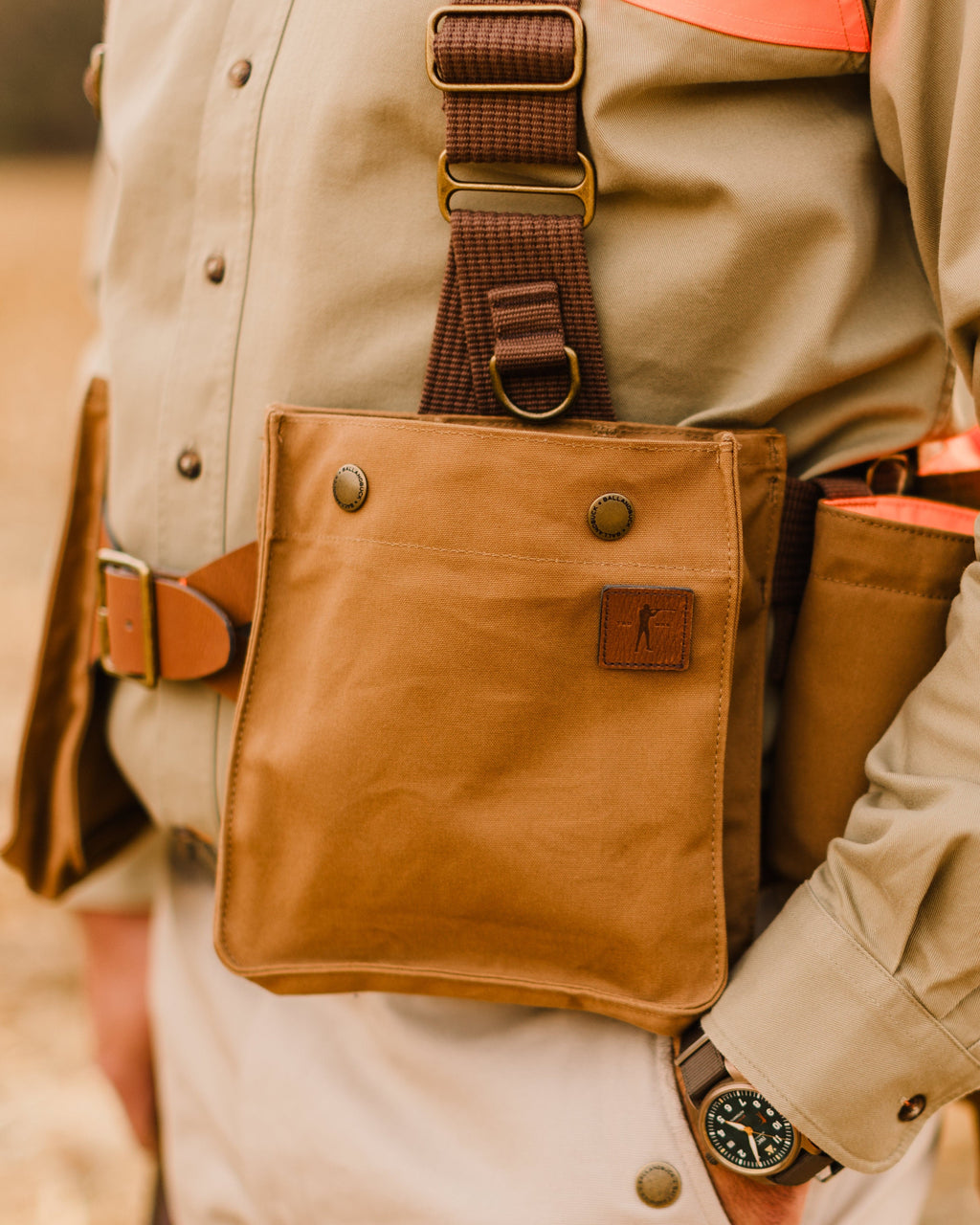 Close-up of the front pockets on the Signature Canvas Strap Vest worn in the field