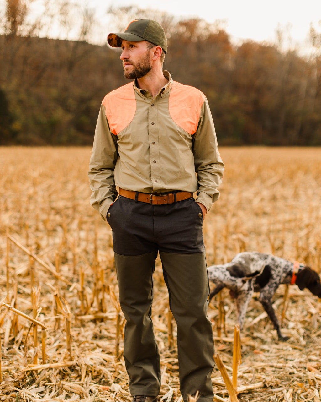 Upland hunter with a bird dog wearing the Ball and Buck leather belt with field pants