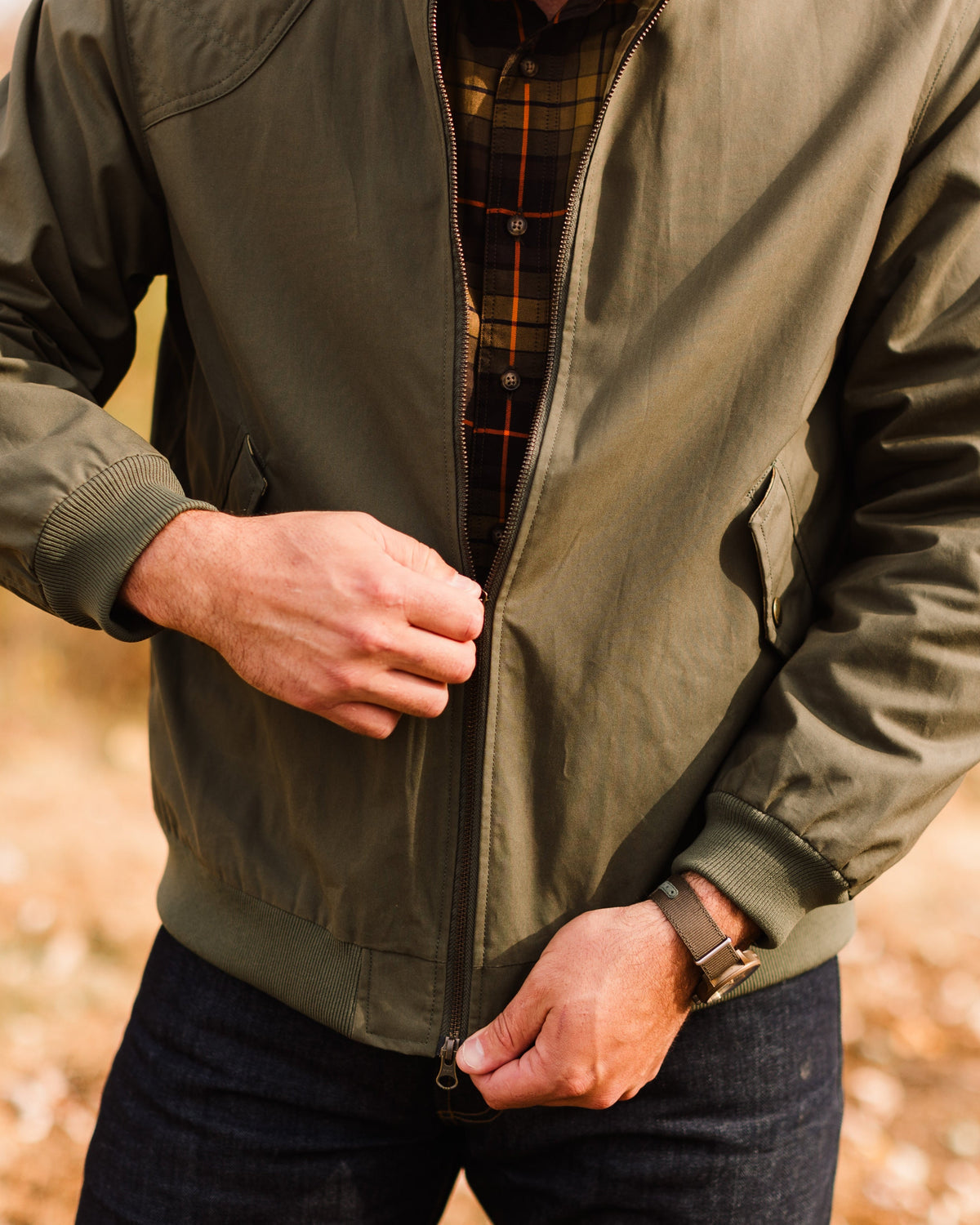 Man zipping the Sage Green Harrington Jacket