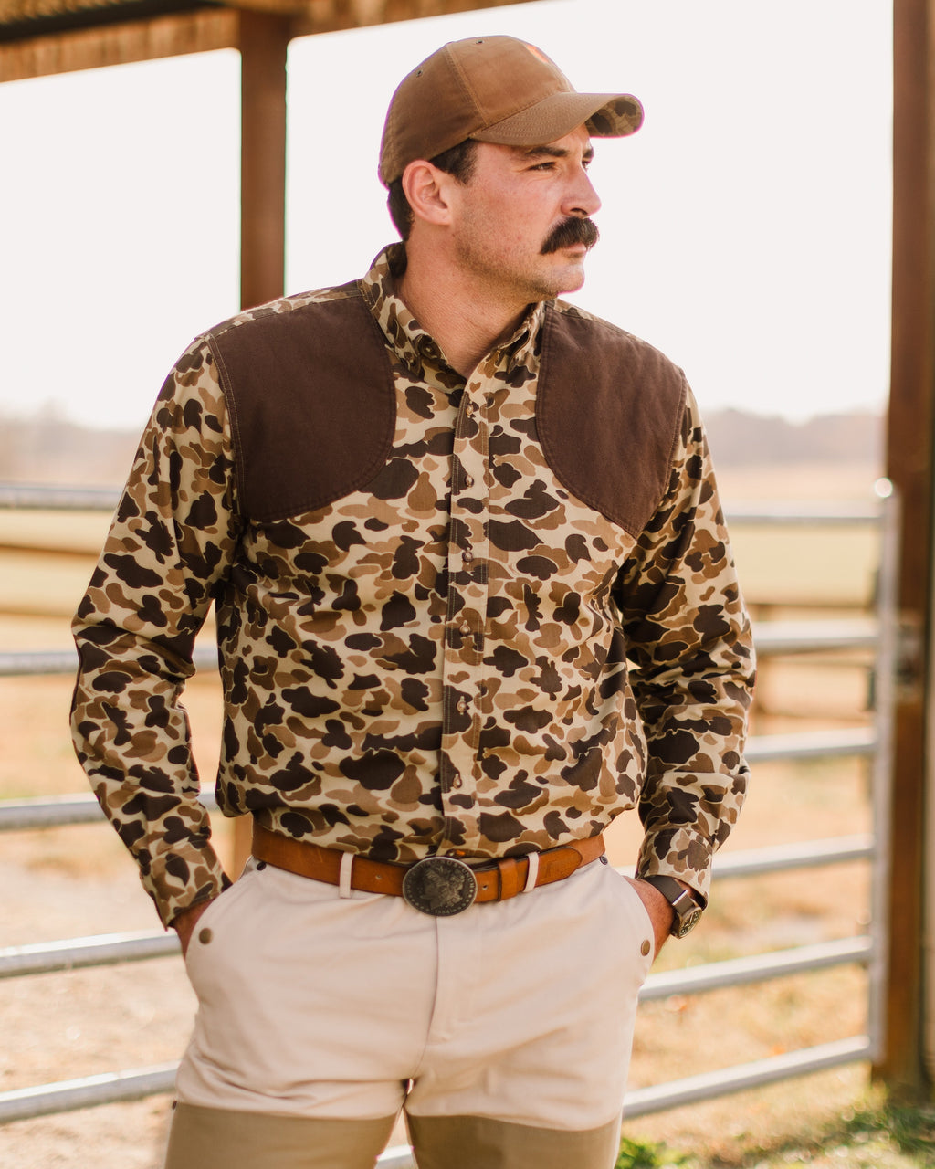 Man wearing the Original Camo Sportsmans Shirt FG and a field cap at a livestock pen