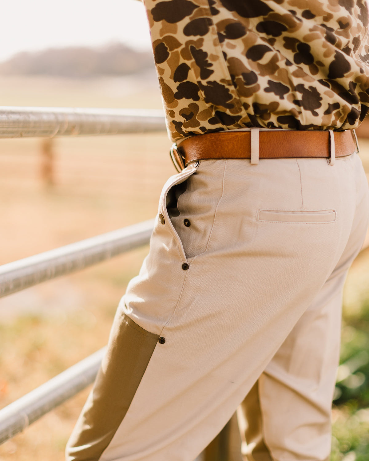 Side view of the Signature Leather belt worn at a pasture gate