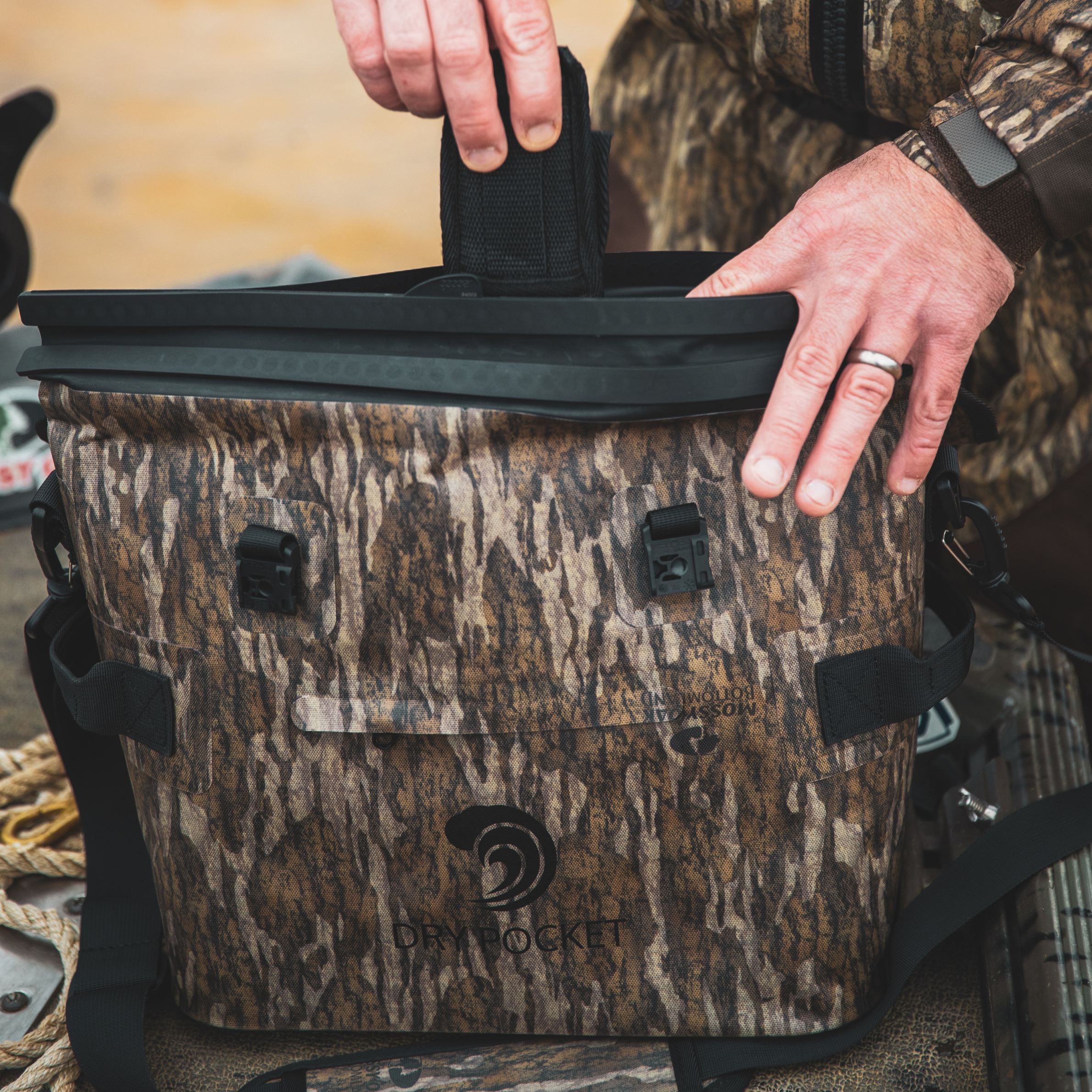 Mossy Oak camo dry bag with black straps and secure lid for hunting gear storage