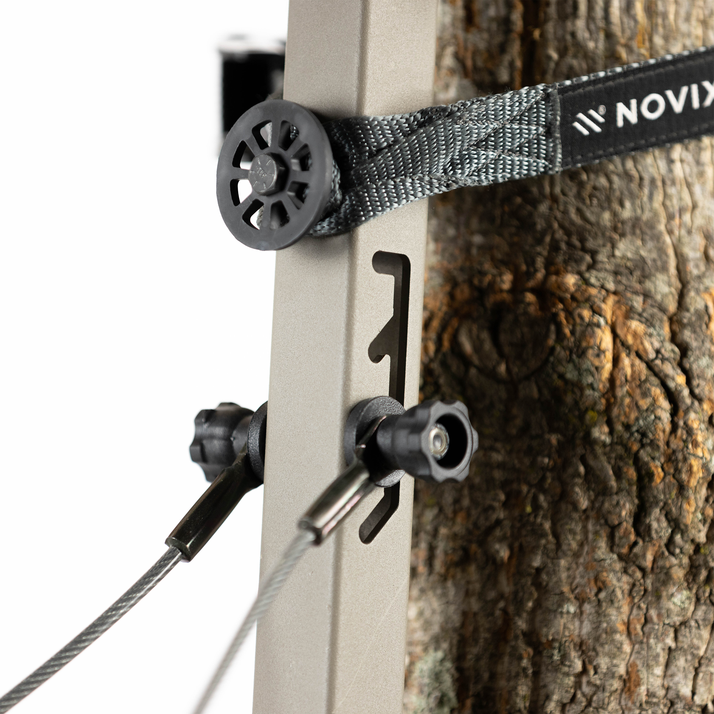 Novix tree stand safety strap with metal cable and adjustment knobs, secured to tree trunk for hunting