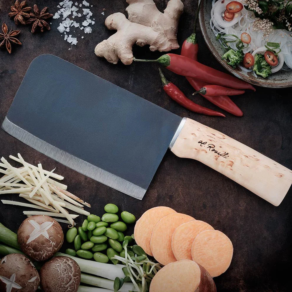 Cleaver knife with wooden handle surrounded by fresh vegetables and spices for cooking