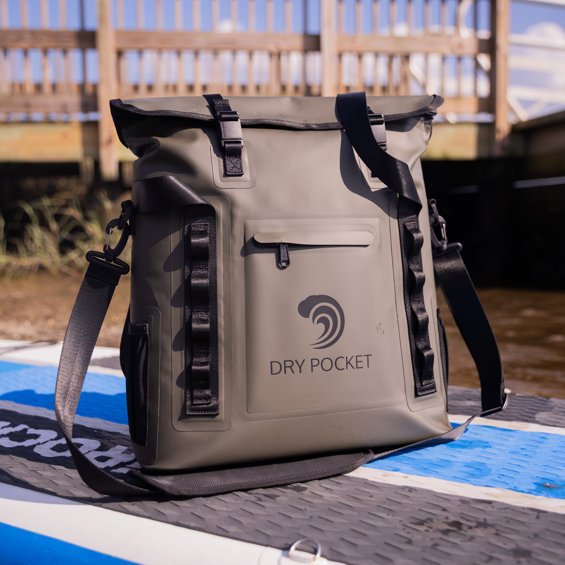 Gray Dry Pocket waterproof dry bag with black straps, ideal for fishing and outdoor adventures on watercraft.