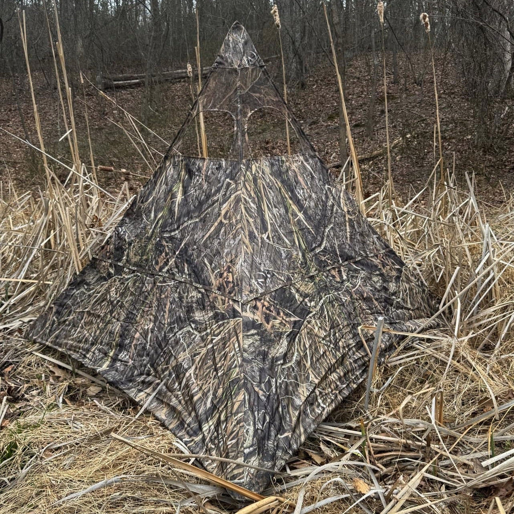 Camo hunting blind in marsh grass, concealment shelter for waterfowl or deer hunting