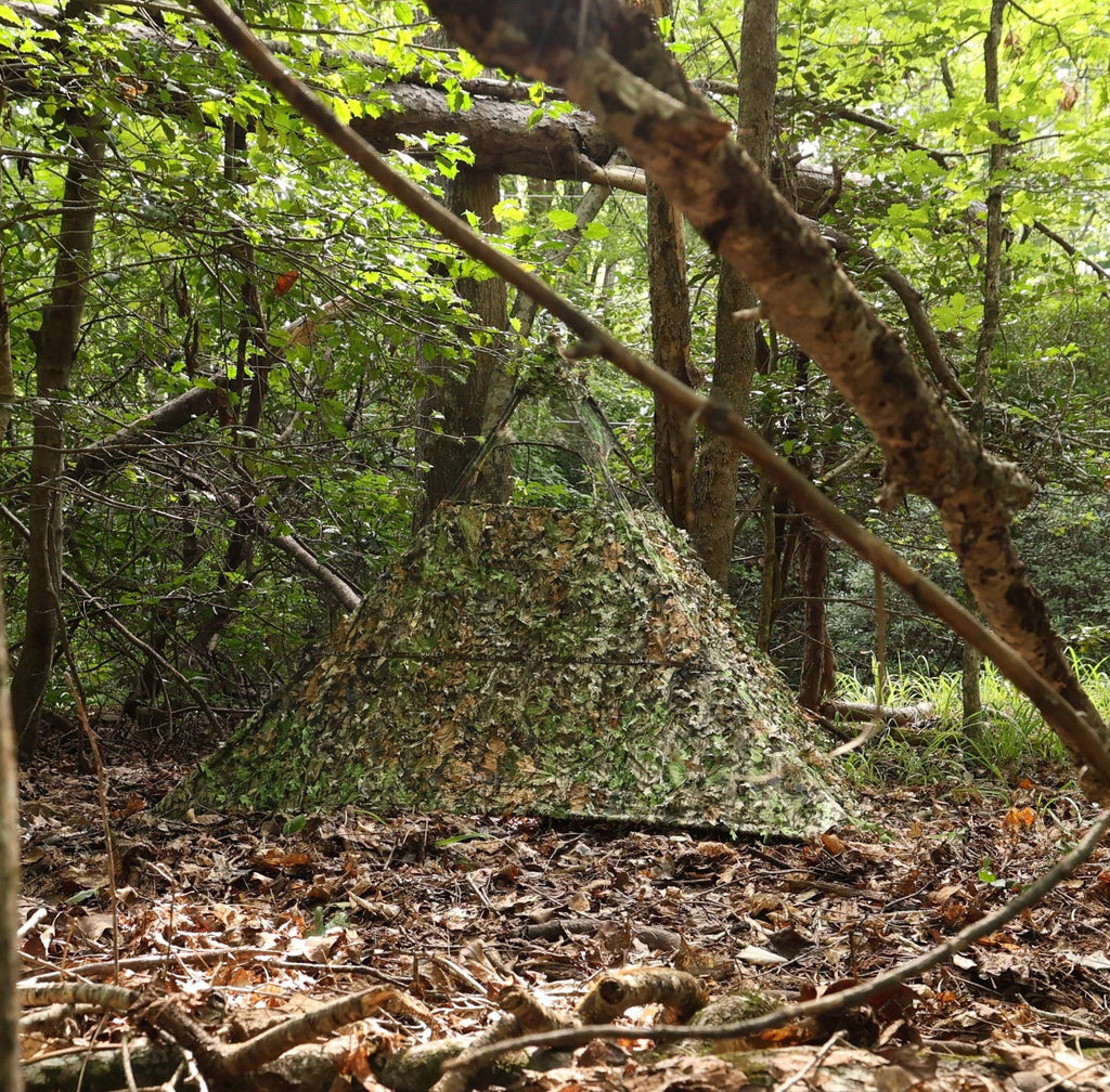 Camouflage hunting blind in dense forest, blending with foliage for concealment during outdoor hunting