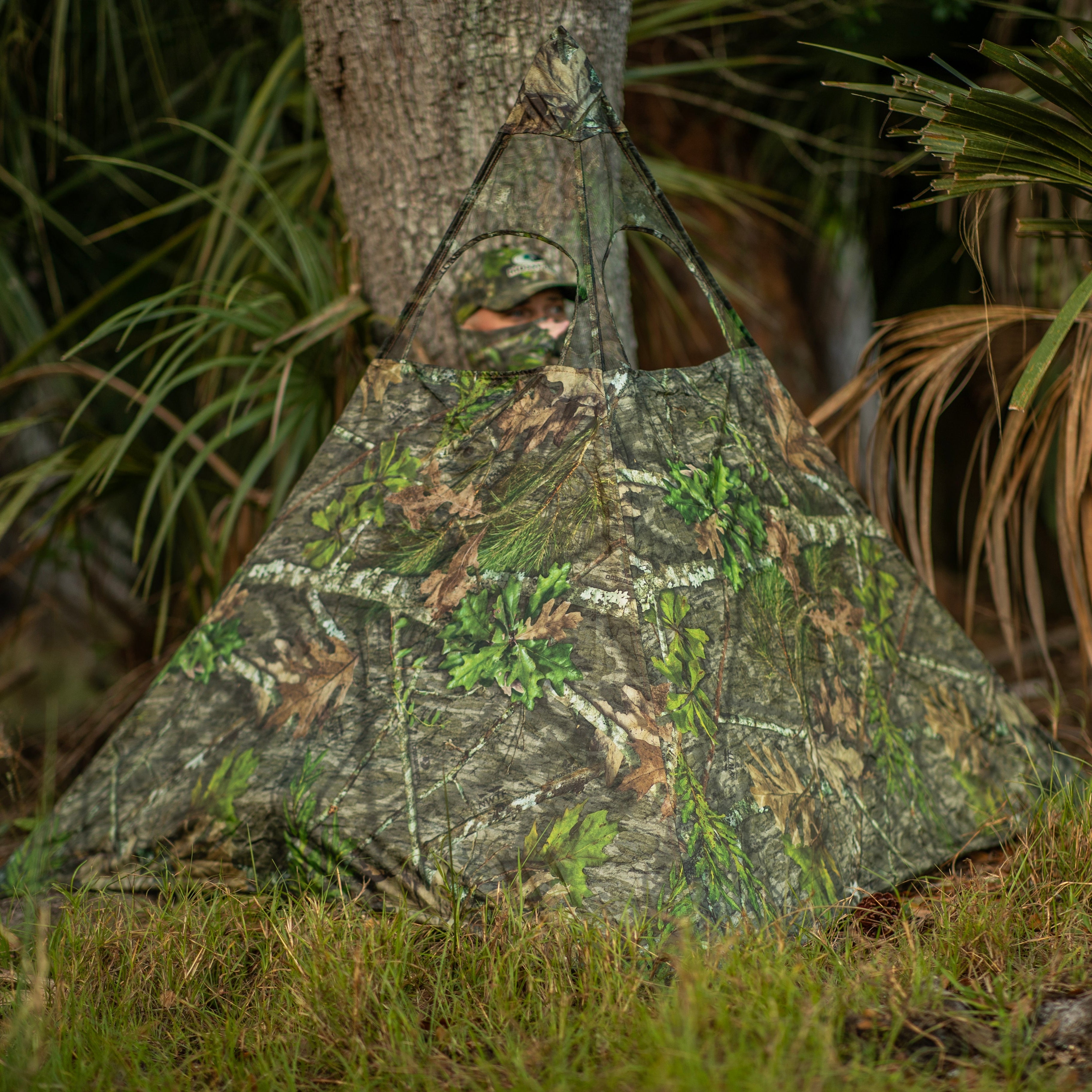 Camouflage hunting blind with leaf pattern, ideal for concealment in wooded areas during outdoor hunts.
