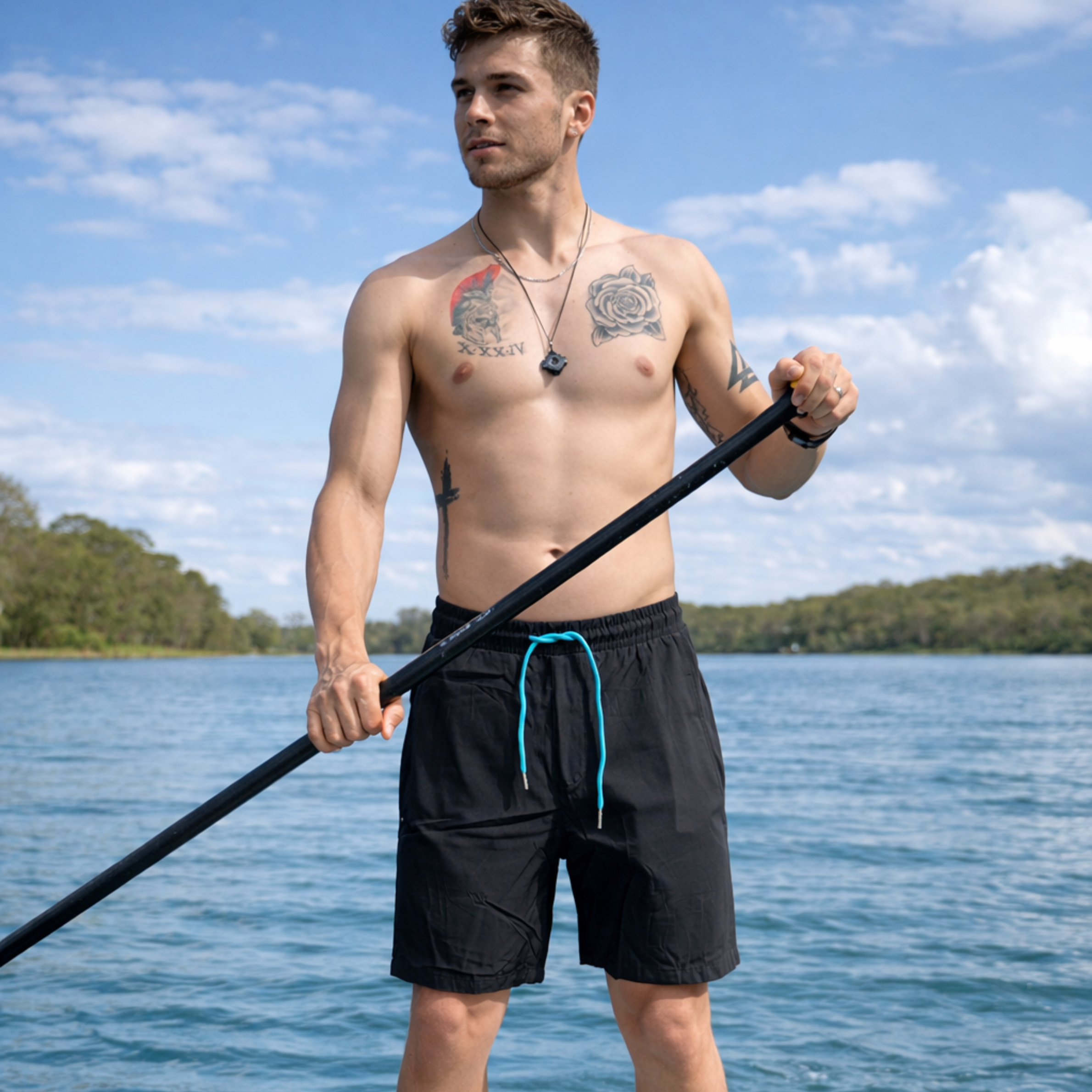 Black quick-dry fishing shorts with blue drawstring, worn on lake for paddling and outdoor adventures