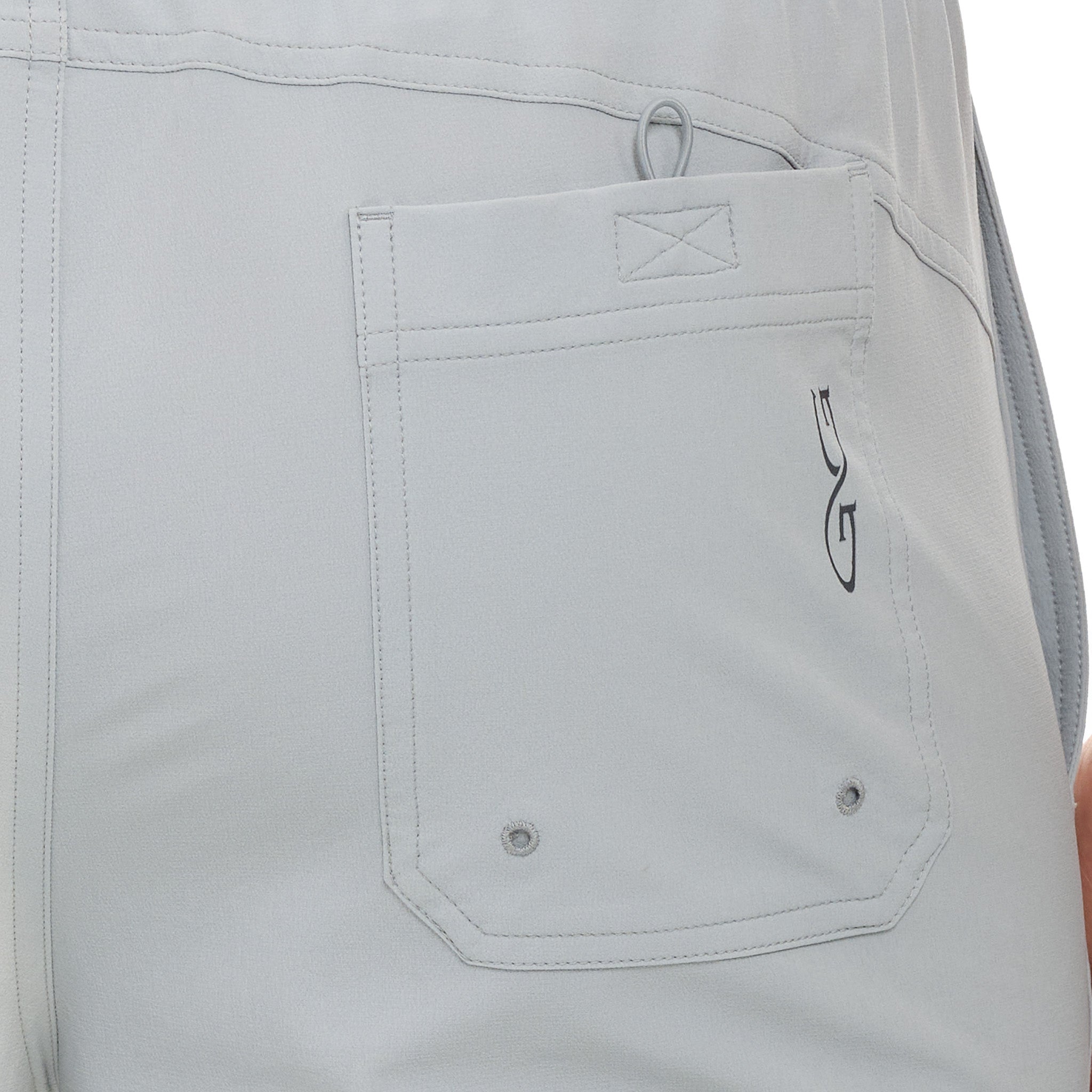 Light gray hunting pants with utility pocket, reinforced stitching, and drainage grommets for outdoor use