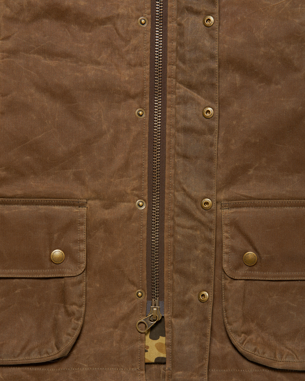 Brass YKK front zipper with the storm flap open on the Dark Oak Upland Vest