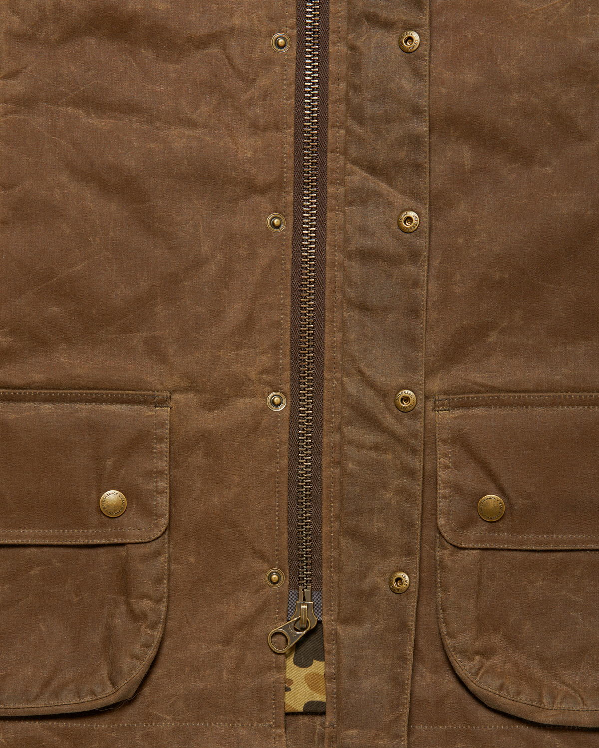 Brass YKK front zipper with the storm flap open on the Dark Oak Upland Vest