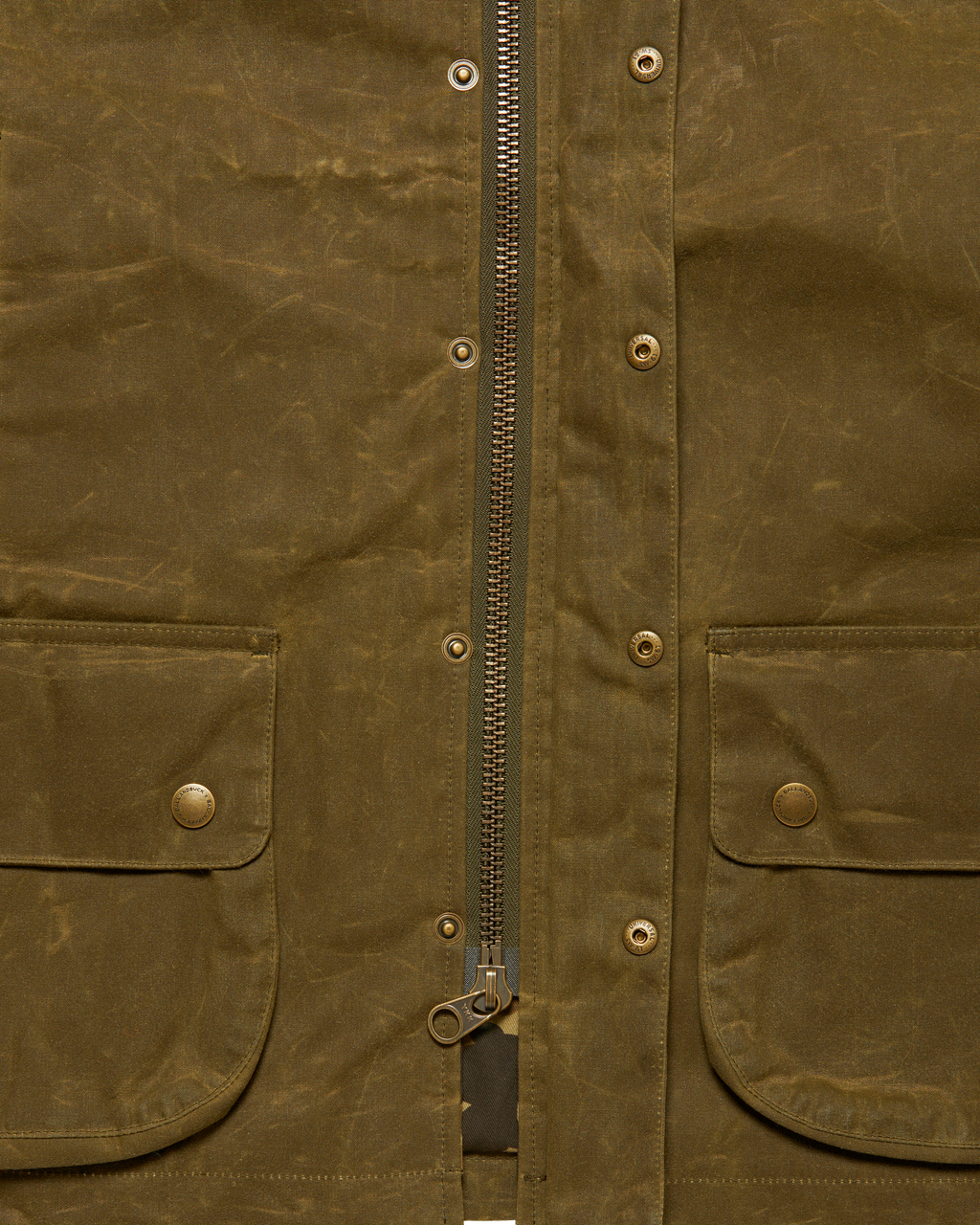 Brass front zipper with the storm flap open on the Olive Upland Vest