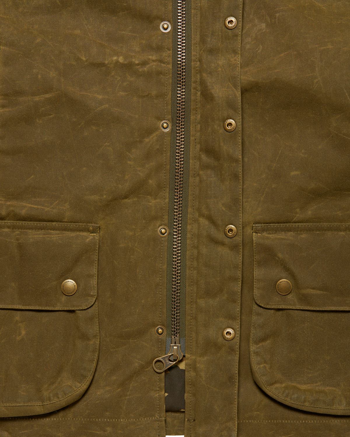 Brass front zipper with the storm flap open on the Olive Upland Vest
