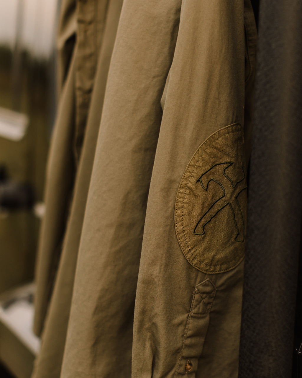 Crossed tomahawks embroidery on the elbow patch of the Jack Carr Hunters Shirt
